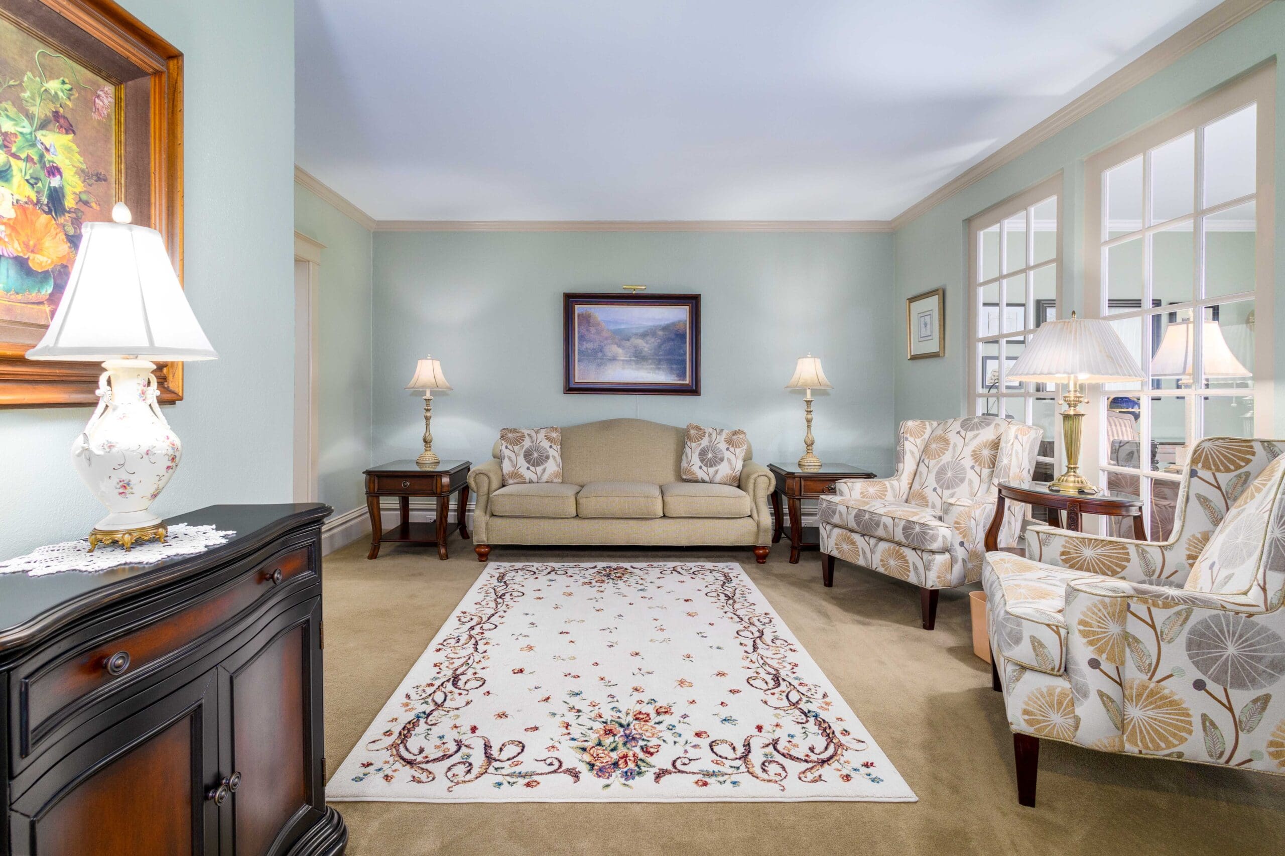 A sitting room at Shorac Funeral Home with sofas, lamps and a patterned rug