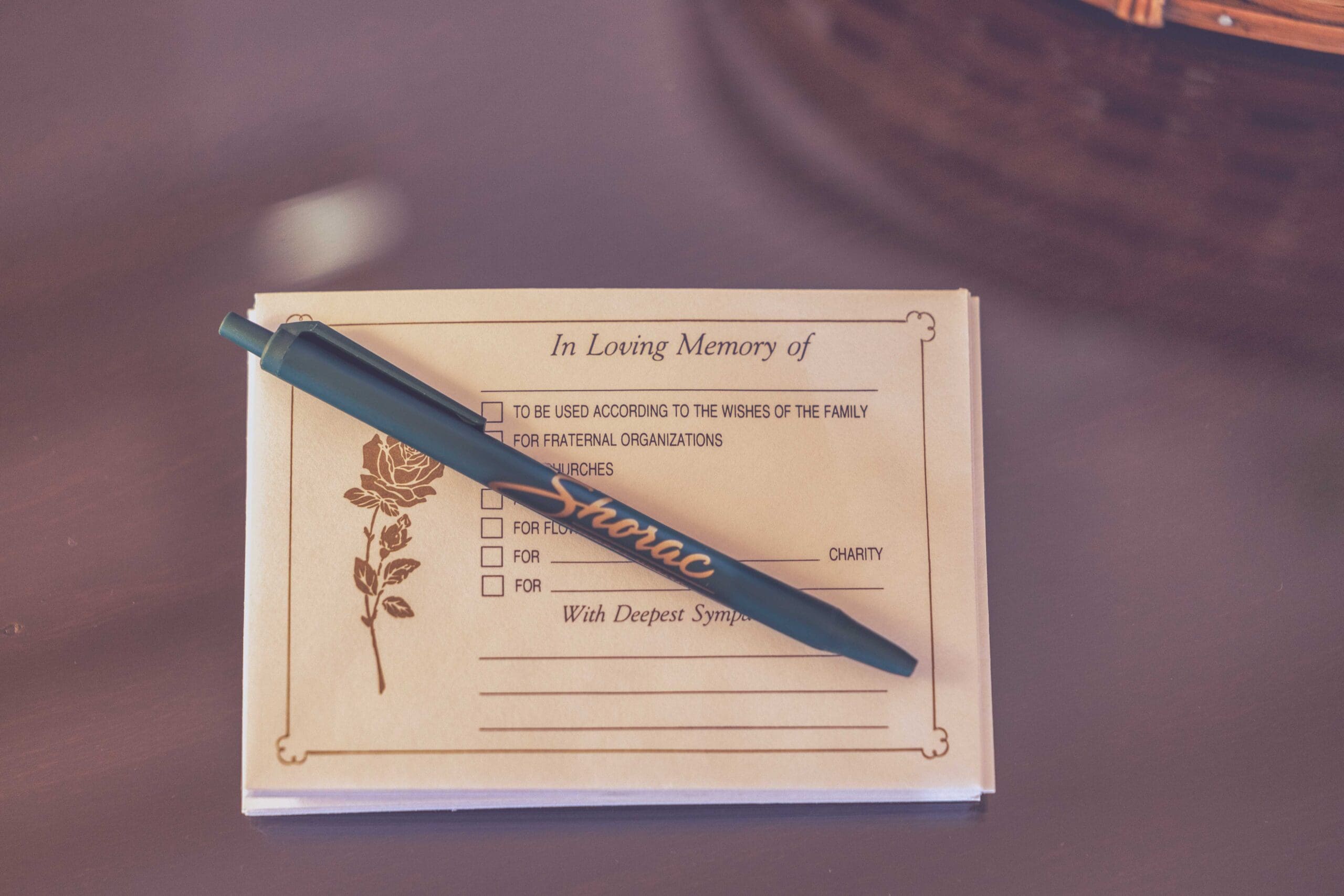 A memorial guest book and pen on a table at Shorac Funeral Home